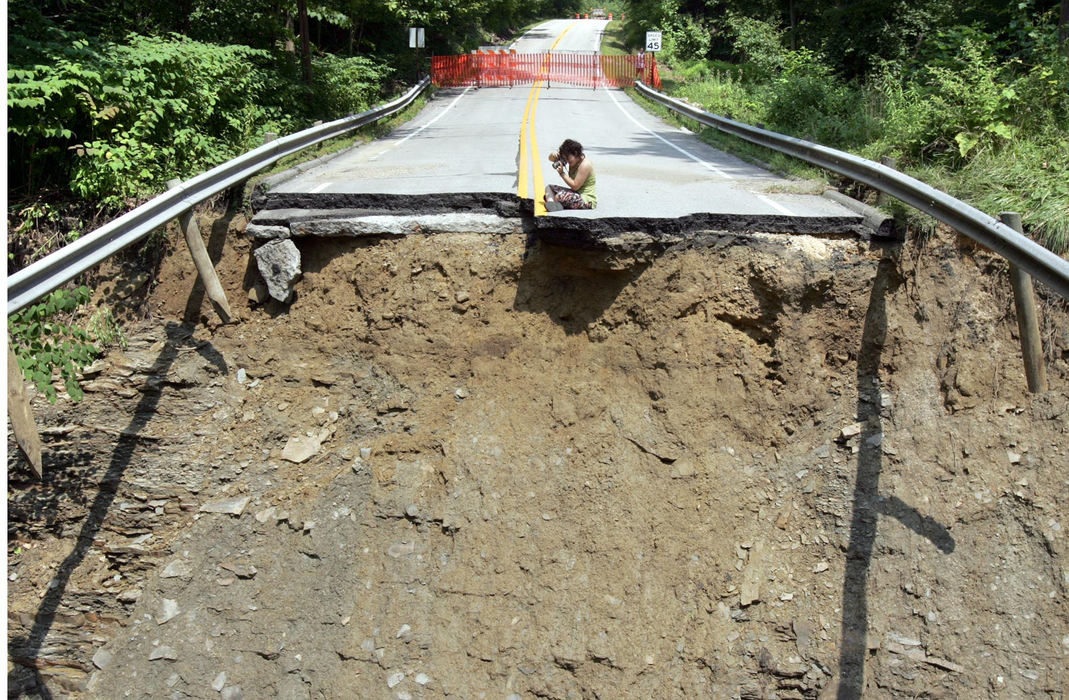 First Place, Team Picture Story - Chuck Crow / The Plain DealerSkye Kellerman, 20, of Geneva, takes pictures of what's left of the Leroy Thompson Road bridge over Phelps Creek in Leroy Township, an area of Lake County that storms and flooding hit hard on July 28. The bridge is among 26 bridges, culverts and roads damaged or destroyed.Skye (cq) Kellerman, age 20, from Geneva, Ohio, stopped to take some pictures of the Leroy-Thompson Rd. bridge in Leroy Twp., Ohio, one of many bridges destroyed in Lake County. Raging waters from Phelps Creek wiped out the bridge last week, leaving a gap in the road of about 30 feet, washed out completely down to the creek. Kellerman is an artist and was taking photos for some future drawings................................Shot at whats left of the Leroy-Thompson Rd. bridge in Leroy Twp., Ohio..Shot on Aug. 1,2006.(Photograph by Chuck Crow/The Plain Dealer)