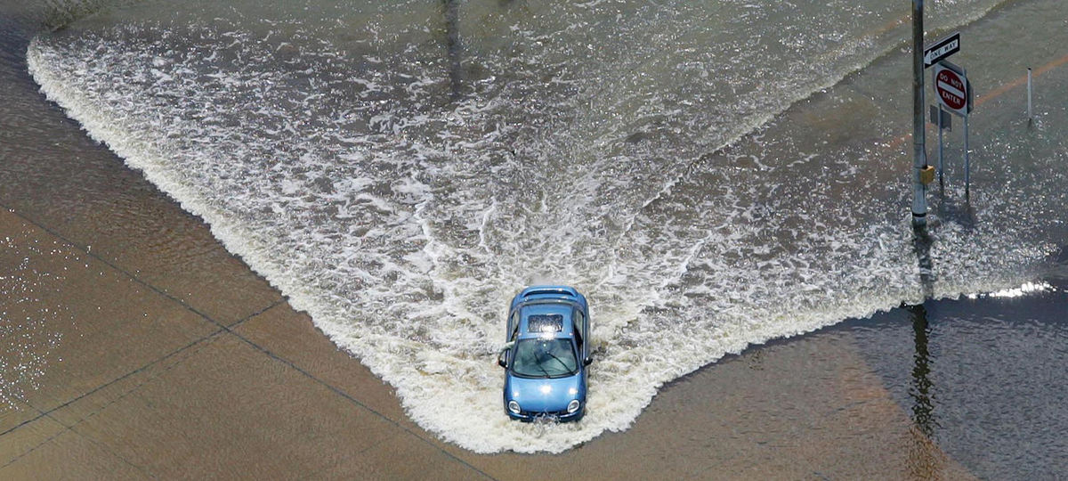 First Place, Team Picture Story - John Kuntz / The Plain DealerA car plows through the flood waters of the Grand River July 28 at the end of Route 44 at the entrance of the Headlands Beach State Park in a risky maneuver in Fairport.    