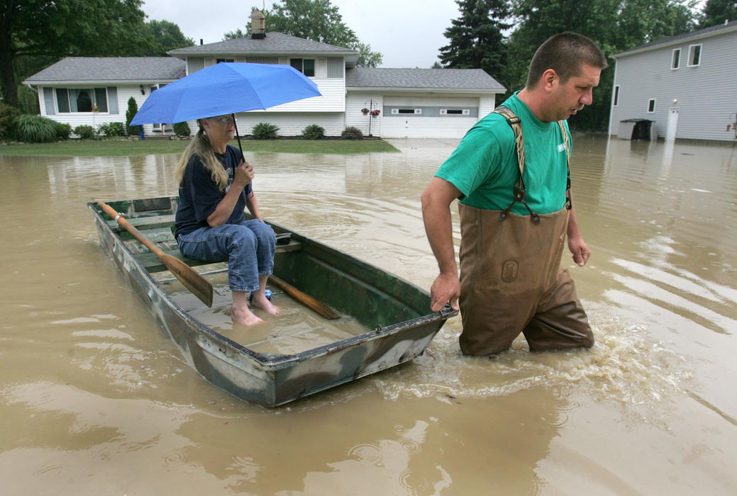 First Place, Team Picture Story - Dale Omori / The Plain DealerStan Cohara pulls a flatboat carrying his mother, Joyce Harrison, down flooded Frances Drive in Valley View on Friday. Cohara transported his mother to his flooded home so she could help him clean it up.  
