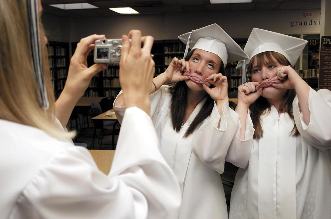 Award of Excellence, Assigned Feature - Cassandra Bergman / Suburban News PublicationsCarolyn Engelhart (left) takes a picture of Shannon Shell (middle) and Cara Dillion making funny faces prior to Grandview Heights High School's graduation ceremony. 