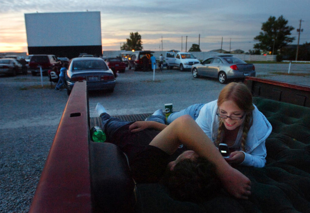 Award of Excellence, Assigned Feature - Luke Wark / Sandusky RegisterSavannah Beard, 17, of Clyde, laughs while checking a text message on her phone as she lays next to her boyfriend Mike Gates, 17, in the back of his truck as they wait for the movie to start at the Star View drive-in in Norwalk. Open almost 59 years, the Star View has given couples and families a friendly place to see movies for decades.