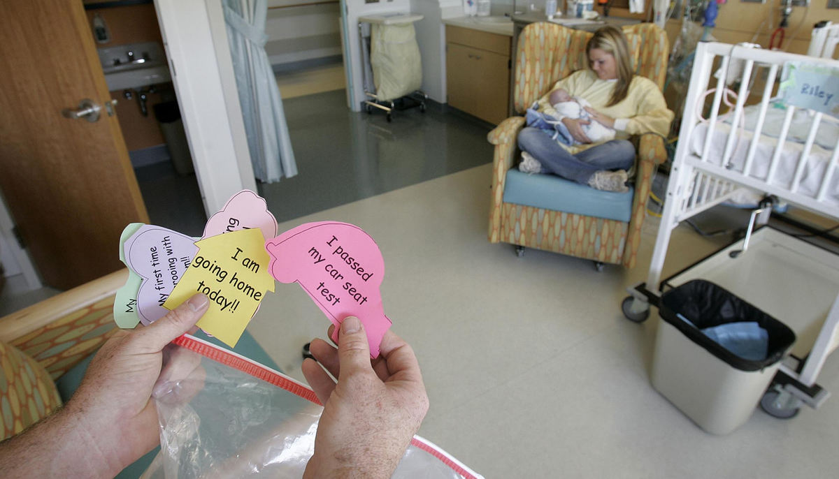 First Place, Feature Picture Story - Chris Russell / The Columbus Dispatch John looks over a list of cards that set goals for Riley to meet before he can leave Children's Hospital and go home while Beth feeds him a bottle for the first time.  