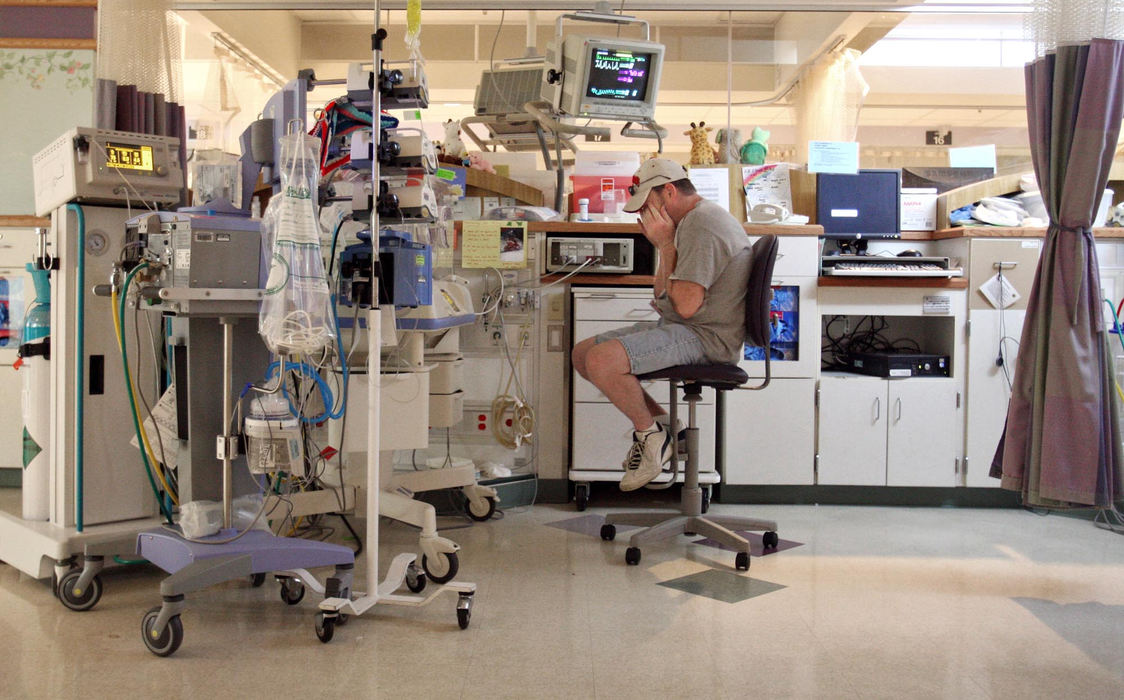 First Place, Feature Picture Story - Chris Russell / The Columbus DispatchSheltered in an incubator that regulates his body temperature and shelters him from infection, Riley is dwarfed by medical equipment that keeps him alive .  Riley's father, John Henry stopped in alone after work, but the parents will not be able to touch Riley for months.  