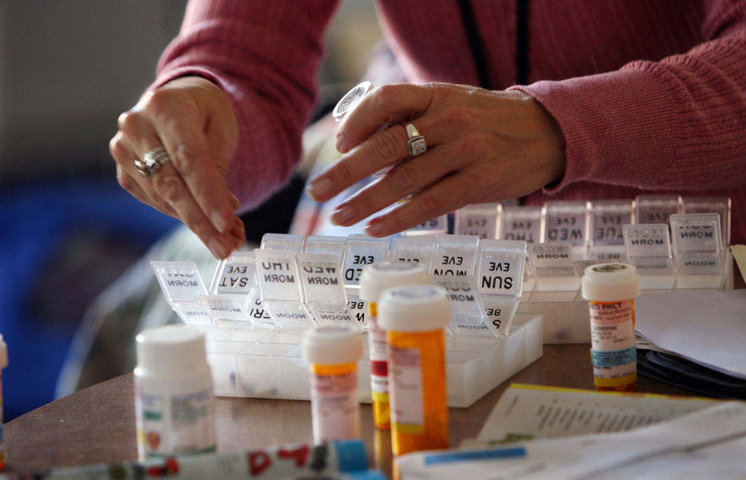 Award of Excellence, Feature Picture Story - Chris Stephens / The Plain DealerSue Johnson fills a pill box, one of the services she provides as a psychiatric nurse.  