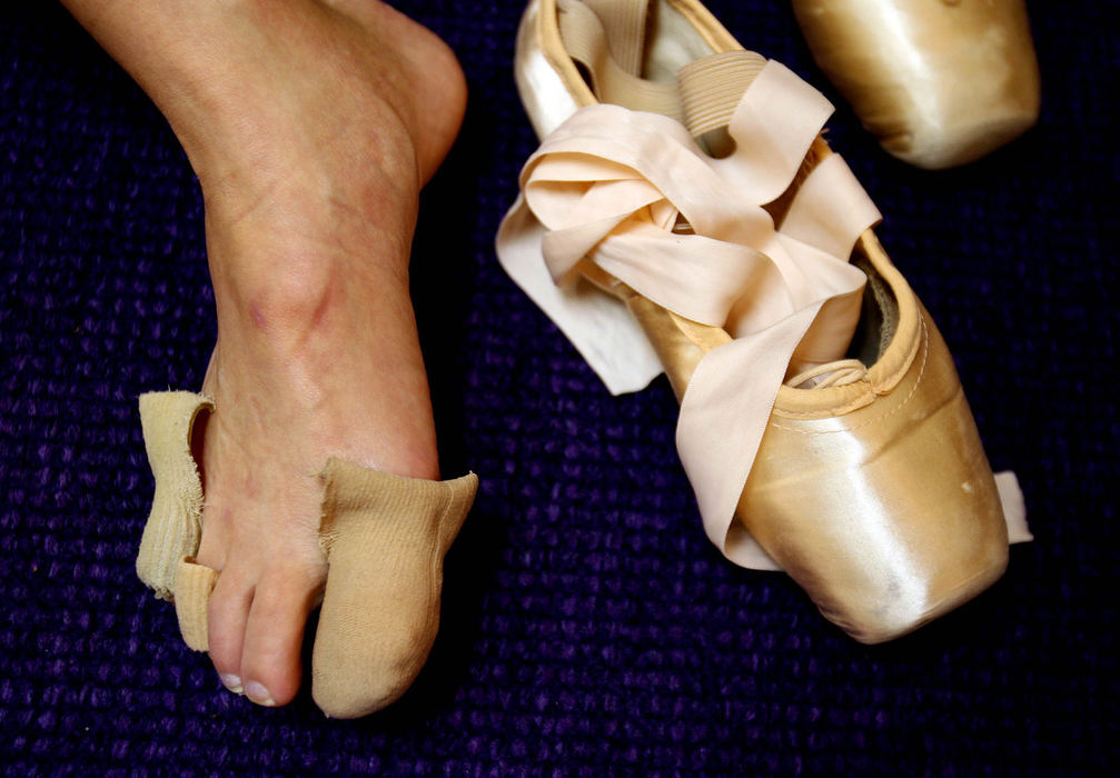 Award of Excellence, Feature Picture Story - Lisa DeJong / The Plain Dealer  Juliana Freude, 22, prepares her feet for her ballet slippers during dress rehearsal for the Nutcracker.