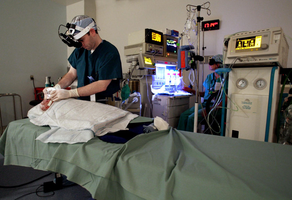 First Place, Feature Picture Story - Chris Russell / The Columbus DispatchIn an underlit operating room, Dr. Rick Golden will make about 1000 laser cuts on each of Riley's eyes to treat for retinopathy of prematurity.  He must cut the abnormal blood vessels that grow and spread throughout the retina.  