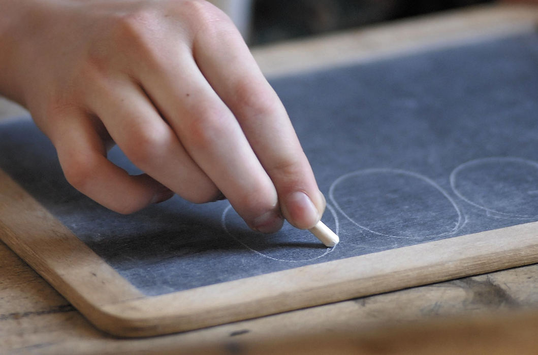 Award of Excellence, Feature Picture Story - Tim Johnson / Suburban News PublicationsA student practices her handwriting skills using chalk to draw circles on a slate writing board.