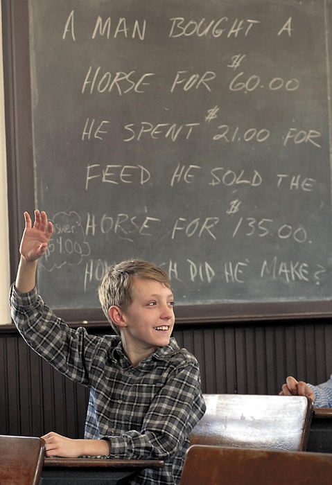 Award of Excellence, Feature Picture Story - Tim Johnson / Suburban News PublicationsAlex York raises his hand to answer a question underneath one of the chalk boards in the one-room schoolhouse.