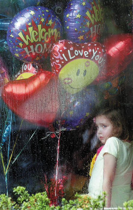 Third Place, General News - Ben French / Suburban News PublicationsSophie Sheridan, 8, looks out of the window at her home on Wexford Road at friends and neighbors upon her return home last Thursday after getting a heart transplant.