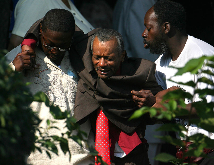 Third Place, News Picture Story - Lisa DeJong / The Plain DealerA family member is overcome with grief as he is helped out of the funeral service for Asteve' Thomas, at Mount Sinai Baptist Church.