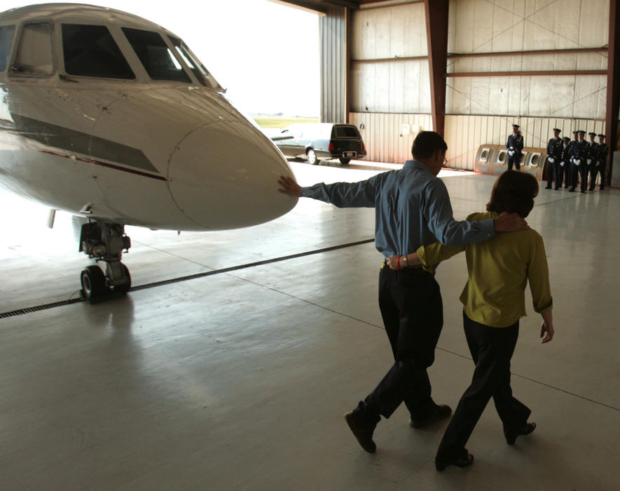 Award of Excellence, News Picture Story - Ken Love / Akron Beacon JournalLes Kuglics, arm in arm with his wife, Donna, reaches out to touch the nose of the plane that holds the body of their son, Matthew. Staff Sgt. Matthew J. Kuglics, returning home on a private charter, was killed after an explosive device struck his vehicle while on his second tour of duty in Iraq. 