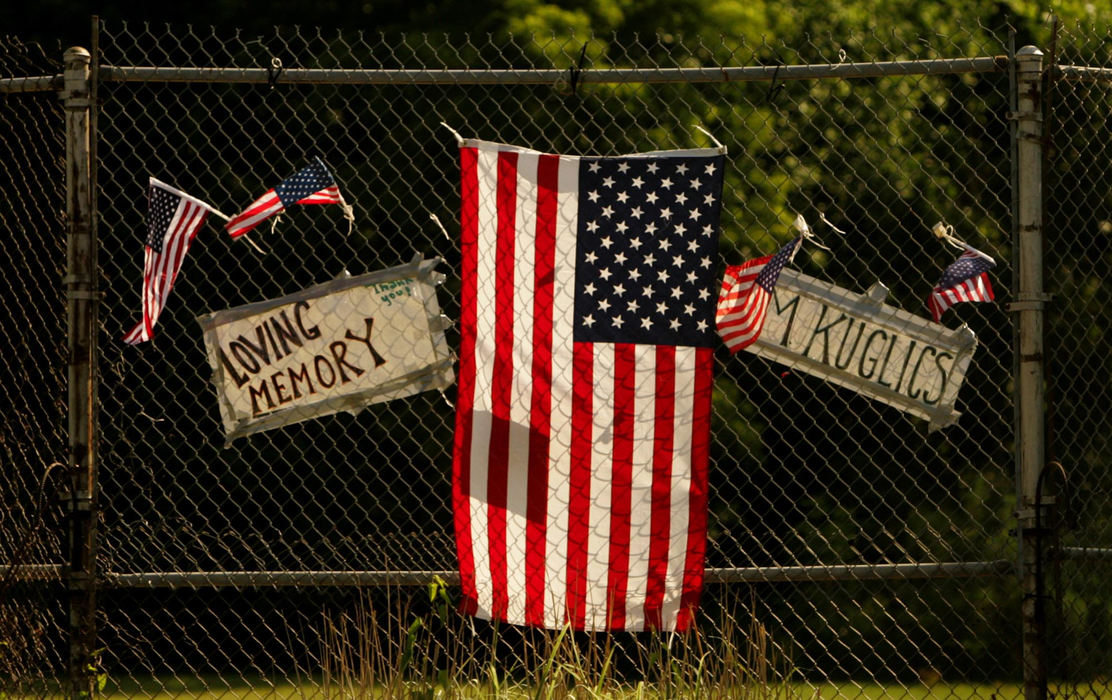 Award of Excellence, News Picture Story - Ken Love / Akron Beacon JournalA tribute to Air Force Staff Sgt. Matthew J. Kuglics hangs on the backstop at a baseball field on the motorcade route from the airport. 