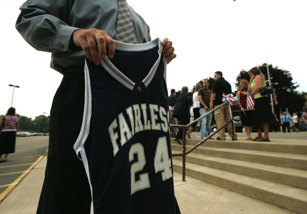 Award of Excellence, News Picture Story - Ken Love / Akron Beacon JournalMatt Kramer the former basketball coach of U.S. Army Cpl. Zachary A. Grass, 22, holds his  basketball jersey outside Fairless High School before the funeral services.