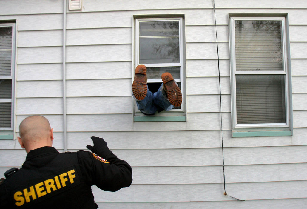 First Place, News Picture Story - Gus Chan / The Plain DealerShawn Bell, of Bell Properties, goes through the window of a foreclosed home under the watchful eye of deputy Rob Kole.