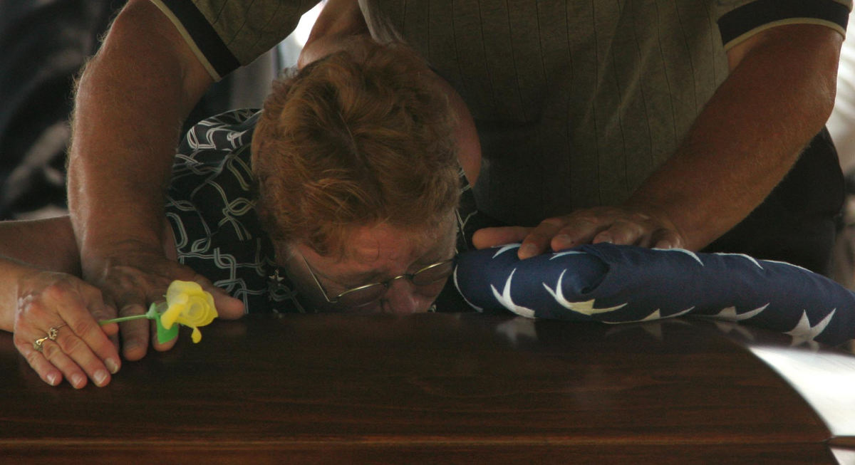 Award of Excellence, News Picture Story - Ken Love / Akron Beacon JournalFrank and Patti Grass, clutch the flag at their son's casket as they grieve during the service at Welty Cemetery in Sugarcreek. Zachary A. Grass died in Iraq on June 16, 2007 in a roadside bombing. 