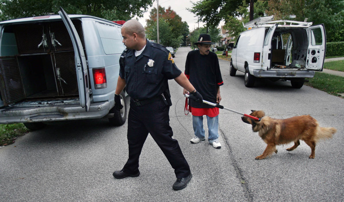 First Place, News Picture Story - Gus Chan / The Plain DealerCleveland dog warden Miguel Santiago takes away a dog owned by Charles Murphy  from a home on E. 70 St.