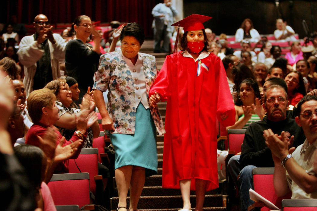 First Place, James R. Gordon Ohio Understanding Award - Gus Chan / The Plain DealerJohanna Orozco gets a helping hand from her grandmother, Juanita Orozco, as she makes her way down the stairs to the playing of Pomp and Circumstance. 