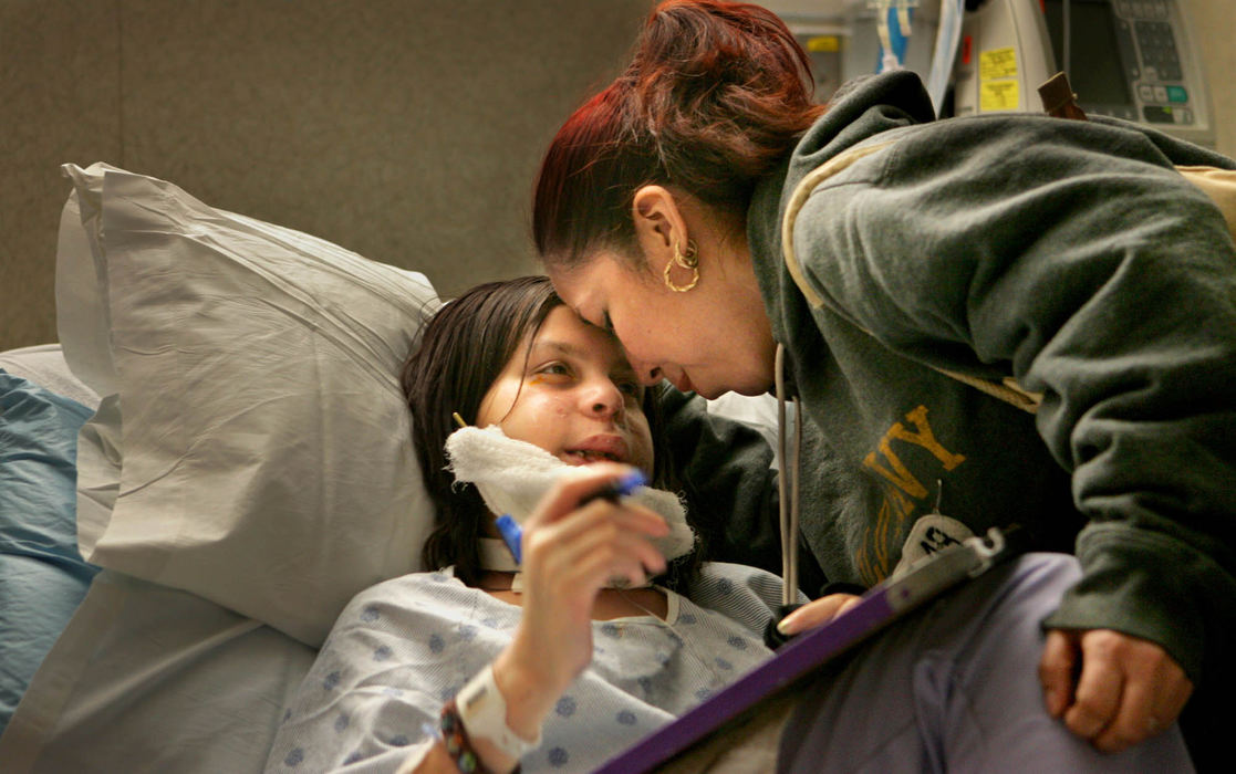 First Place, James R. Gordon Ohio Understanding Award - Gus Chan / The Plain DealerJohanna Orozco is greeted by her godmother, Fabiola Mijangos, in her room at MetroHealth Center.
