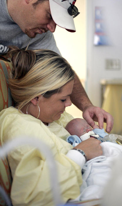 Second Place, James R. Gordon Ohio Understanding Award - Chris Russell / The Columbus DispatchJohn holds hands with Riley while Beth  gets to hold Riley for only the second time since his arrival at Children's Hospital in May.  