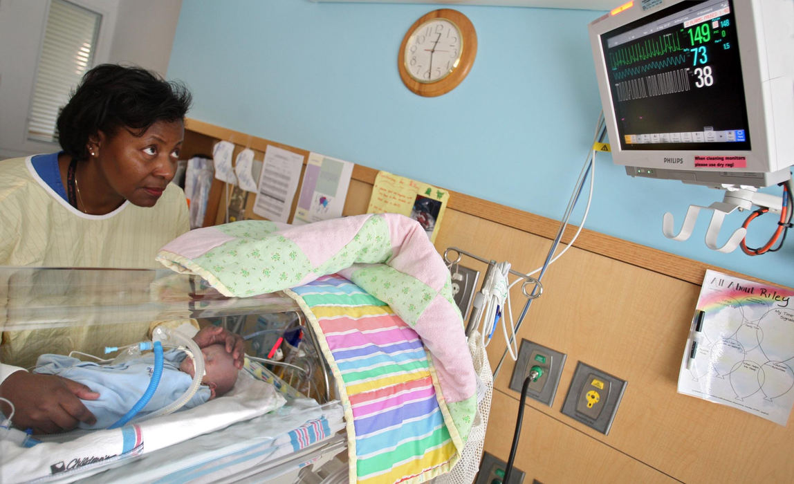 Second Place, James R. Gordon Ohio Understanding Award - Chris Russell / The Columbus DispatchRN Rose Smith looks up to check Riley's vitals after he was taken off the ventilator that was breathing for him. Although he is breathing for himself he will receive supplemental oxygen. 