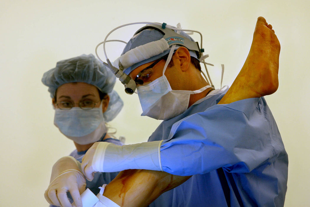 First Place, James R. Gordon Ohio Understanding Award - Gus Chan / The Plain DealerDr. Michael Fritz applies a tourniquet to cut off blood supply to the leg in which skin and bone will be removed and sewn to create Johanna's new jaw at MetroHealth.