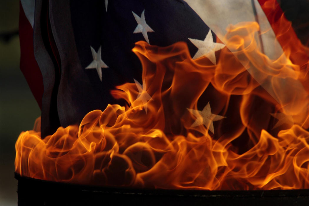 Award of Excellence, Pictorial - Jame D. DeCamp / The Columbus DispatchA flag is lowered into a burning drum during a flag disposal ceremony provided by the American Legion Post 171 and the VFW Post 7883, June 14, 2007 in Westerville.  This was one of more than 200 flags the were 'retired' during the two hour ceremony.