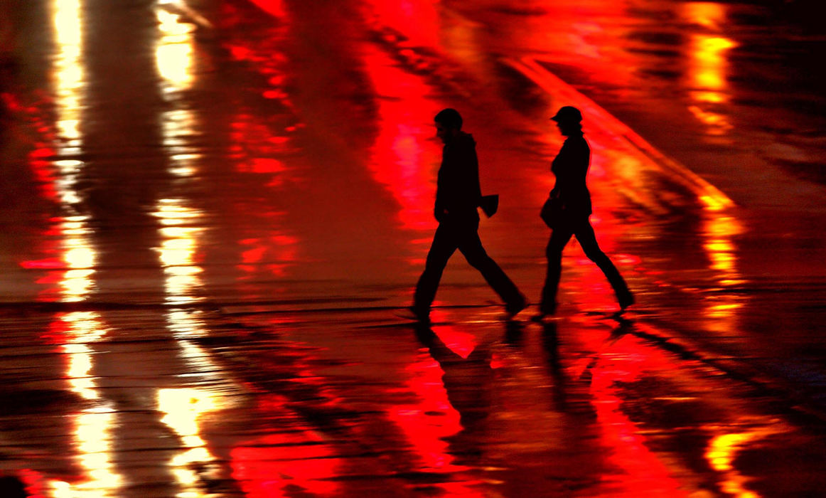 Award of Excellence, Photographer of the Year - Ken Love / Akron Beacon JournalA couple crosses South Main as lights reflect on the rain soaked street in Akron.
