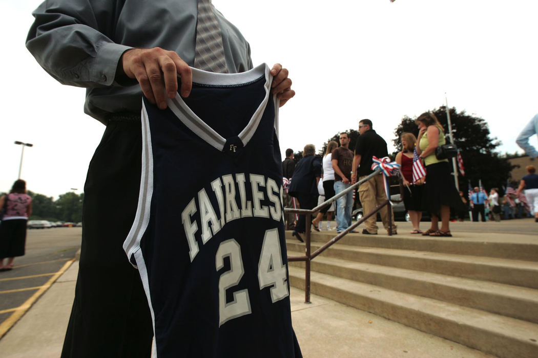 Award of Excellence, Photographer of the Year - Ken Love / Akron Beacon JournalMatt Kramer the former basketball coach of U.S. Army Cpl. Zachary A. Grass, 22, holds his  basketball jersey outside Fairless High School before the funeral services.