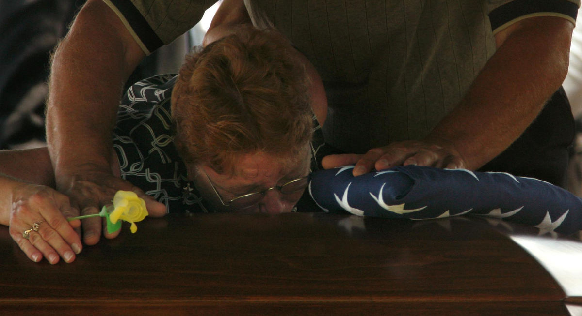 Award of Excellence, Photographer of the Year - Ken Love / Akron Beacon JournalFrank and Patti Grass, clutch the flag at their son's casket as they grieve during the service at Welty Cemetery  in Sugarcreek. Zachary A. Grass died in Iraq on June 16, 2007 in a roadside bombing. 