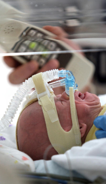 First Place, Photographer of the Year - Chris Russell / The Columbus DispatchVisiting the hospital by himself, John learns that Riley is breathing well enough to be taken off the ventilator and will be able to breathe for himself and cry for the first time.  John holds a telephone up for Beth who had to stay home. 