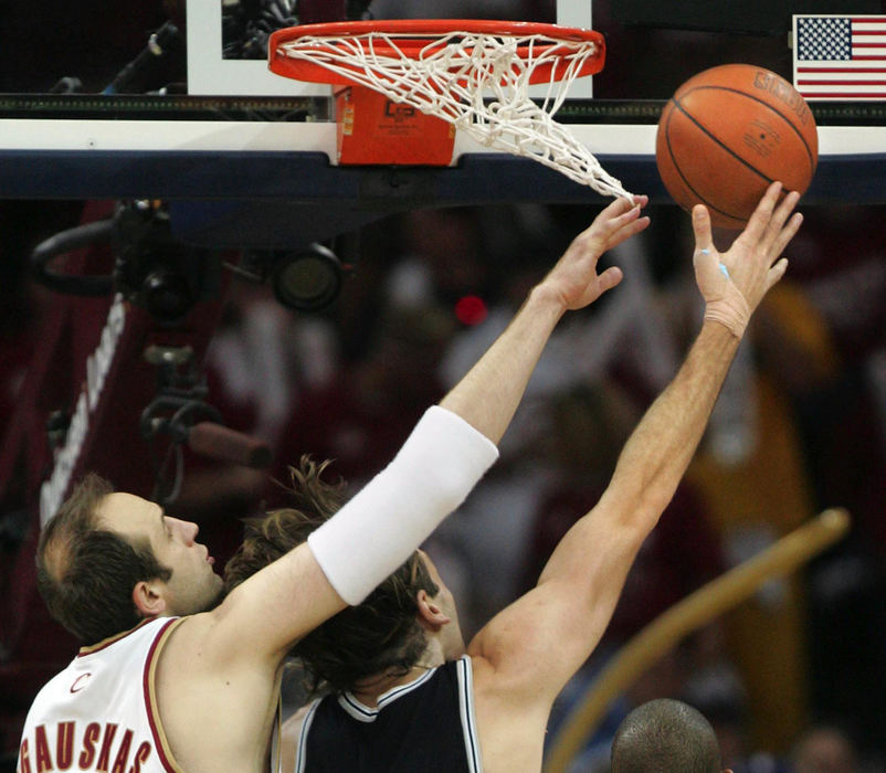 Award of Excellence, Photographer of the Year - Phil Masturzo / Akron Beacon JournalCleveland Cavaliers Zydrunas Ilgauskas, left, gets tangled in the net trying to block a shot by San Antonio Spurs' Fabricio Oberto  during second half game action. 