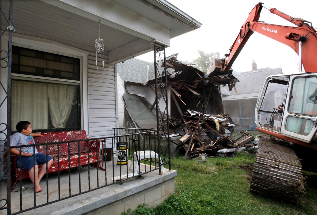 First Place, Photographer of the Year - Chris Russell / The Columbus DispatchTyler Bohlen, 7, has a ringside seat as the City of Columbus demolishes the house next door which was abandoned and being used as a drug house. 