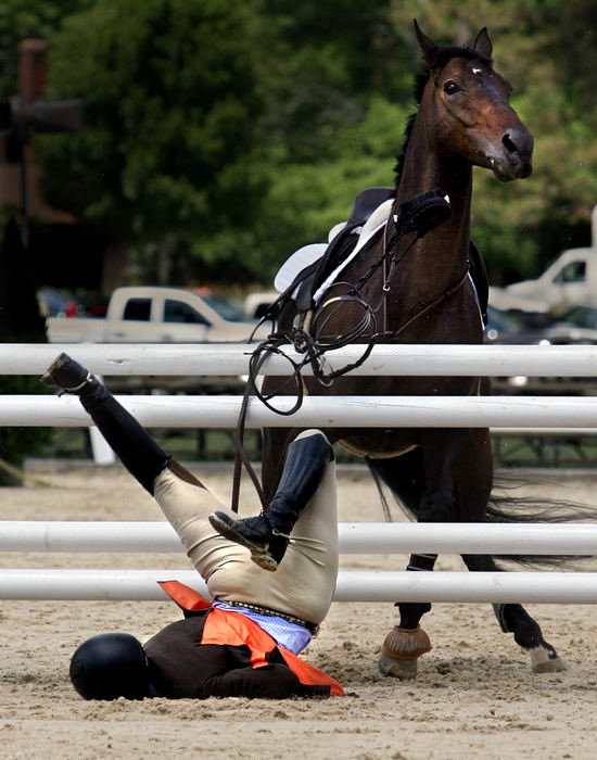 Second Place, Photographer of the Year - Lisa DeJong / The Plain DealerKate Fogarty, 20, of Chardon flies head first over cross rails after her horse stopped short before making the jump during the Adult Jumper competition during the Chagrin Valley Jumper Classic in Moreland Hills  " I kept going and he didn't," she said. Fogarty, who miraculously walked away unhurt, said that it was her mistake when she leaned up on his neck before the jump instead of asking her horse to leave the ground with her legs, she said. 