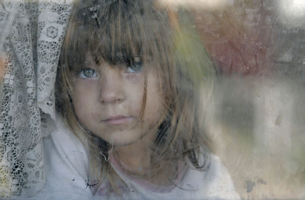 Second Place, Portrait/Personality - Doral Chenoweth III / Taylor Marcum, 4, stares out of her family's South Side home. Due to the fallout from the foreclosure crisis, her mother, Jami  Robinette, has had trouble figuring out where to send the rent check for this house.