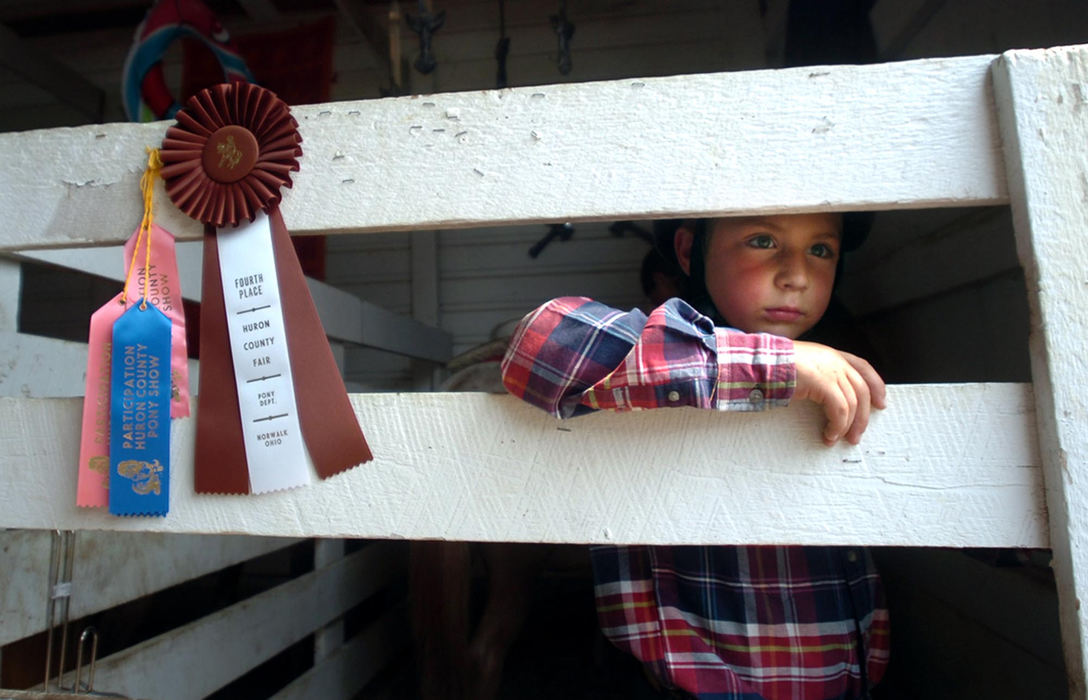Award of Excellence, Portrait/Personality - Stephanie J. Smith / The Morning JournalMiles Robles, 7, of Norwalk, stands next to numerous ribbons he and his family won while waiting for his mother to prepare their pony, Bunny, to show at the Huron County Fair.