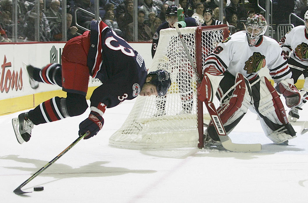 Award of Excellence, Sports Action - Neal C. Lauron / The Columbus DispatchFredrik Modin, 33, tries to keep control of the puck as he trips behind the the Chicago Blackhawks goal while trying to sneak behind Blackhawks goal tender Nikolai Khabibulin, 39, in the first period of their game at Nationwide Arena, February 11, 2007. 
