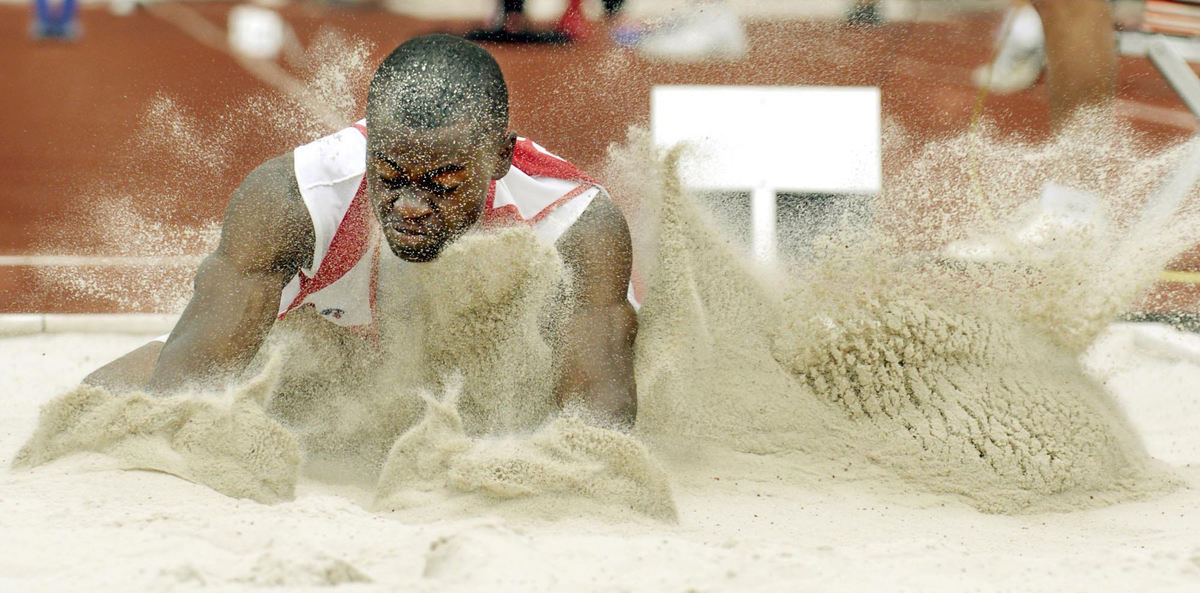 Award of Excellence, Sports Action - Maribeth Joeright / The News-HeraldVilla Angela-Saint Joseph High School's Justinn Eddie sends a spray of sand after his jump in the State Track and Field Division III long jump in Columbus. Eddie took second place.