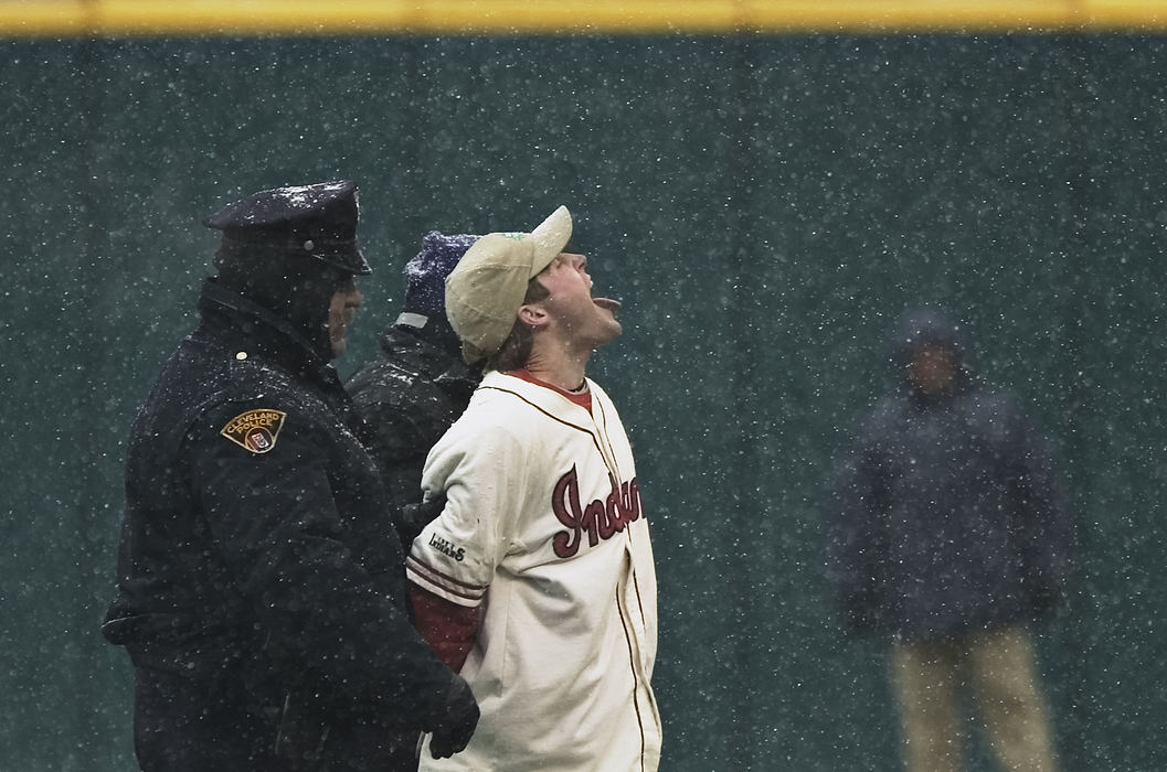 Award of Excellence, Sports Feature - Andrew Dolph / Medina GazetteA Cleveland Indians fan is escorted off Jacobs Field after attempting to make snow-angels in right field during the third weather delay of the Tribe's home-opener against Seattle, April 6, 2007. The game was finally called after the fourth weather delay by crew chief Rick Reed, just one pitch away from being legal.