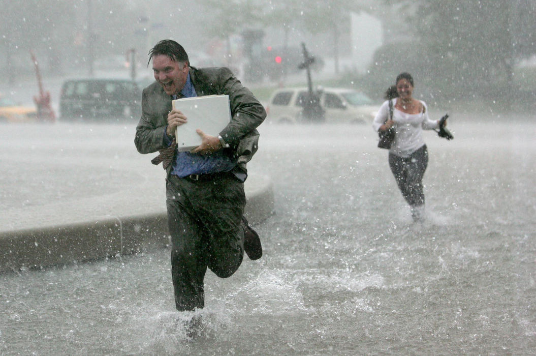 Third Place, Spot News over 100,000 - Peggy Turbett / The Plain DealerChris Ronayne and Michele Mulcahy dash through an afternoon deluge for a meeting at the Rock and Roll Hall of Fame in Cleveland. 