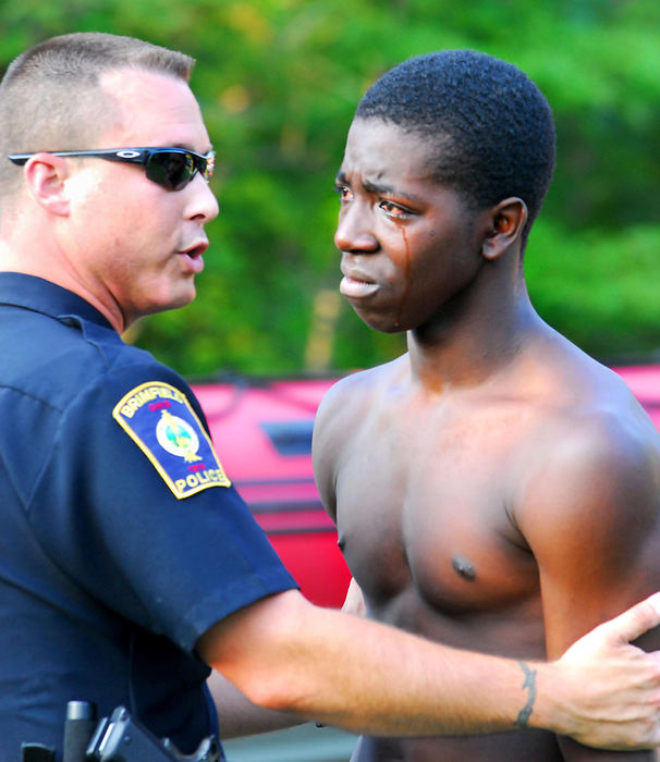 Third Place, Spot News under 100,000 - Stephanie Krell / Record-CourierBrimfield Police Officer Russell Diehl comforts the older brother of a teenaged Cleveland youth, Ronzell Carter, 15, who drowned at Sandy Lake in Rootstown, July 31, 2007. The three young male relatives flipped a paddle boat they were playing on not realizing that the one boy couldn't swim. 