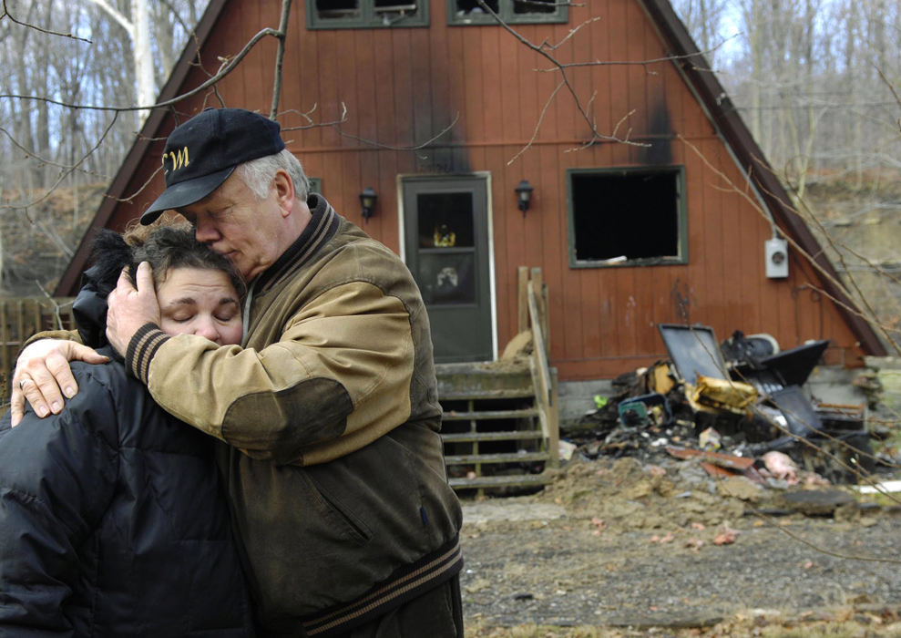 Award of Excellence, Spot News under 100,000 - Duncan Scott / The News-HeraldPastor Hannu Vepsalainen comforts Michele Brentar outside her home at 6720 Fay Road in Concord Township. The house was gutted by fire Christmas day, killing a family dog. Vepsalainen, a neighbor of Anthony and Michele Brentar's, is spearheading a donation drive for the Brentar's.