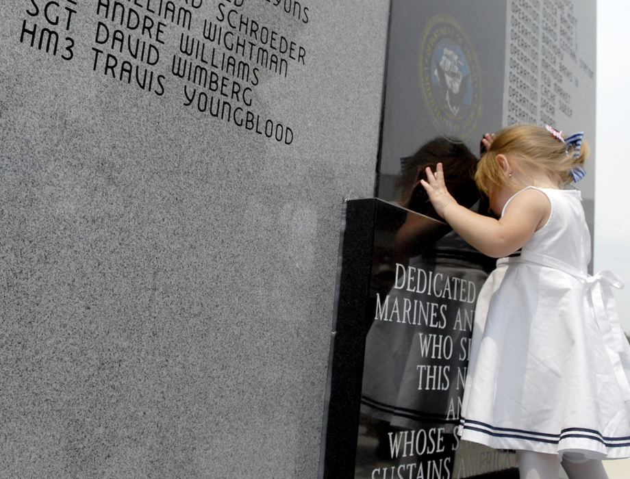 First Place, Student Photographer of the Year - David Foster / Kent State University18 month old Emma Youngblood of Columbus leans on the memorial next to her father's name. HM3 (Hospital Medic) Travis Youngblood never had a chance to meet his daughter, he died in combat in 2005. The Lima Company dedicated the memorial in remembrance of fallen soldiers at Rickenbacker Air National Guard Base. 