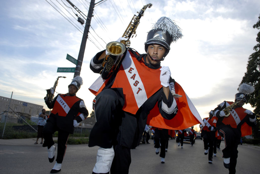First Place, Student Photographer of the Year - David Foster / Kent State UniversitySenior saxophone leader Austin Kellum marches with the East High School show band down Long Street in Columbus.  The East High School show band is a source of pride for the school and the students' neighborhood. Before home games, the band gets into their uniforms and warms up. Then the band buses over to the original East High School and begins a 20 minute march to the stadium. The march goes through a high crime rate area of town. People come out to watch the band on the street and in front of their homes. 