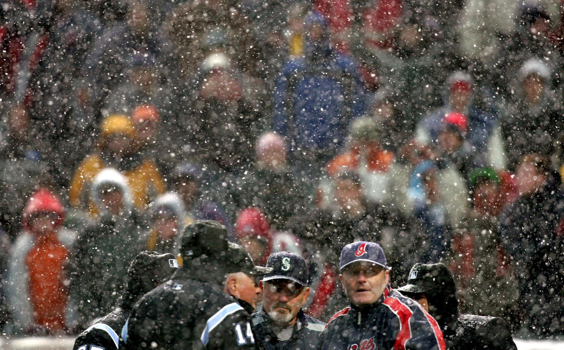 Third Place, Sports Picture Story - Chuck Crow / The Plain DealerCleveland Indians manager Eric Wedge meets with the umpires and Seattle manager Mike Hargrove during the 3rd snow delay of the opening day game in Cleveland. The Indians were winning 4-0, in the top of the 5th inning, Seattle had the bases loaded, with 2 outs and the count was 1 ball and 2 strikes on Seattle's Jose Lopez. One more strike and the game is official, but the snow delay put the game on hold again. The game was eventually postponed and the Indians starting pitcher Paul Byrd lost a no hitter to boot. 