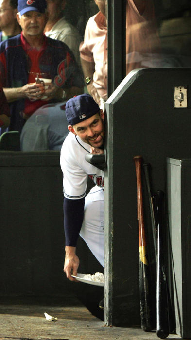 Third Place, Sports Picture Story - Chuck Crow / The Plain DealerBoys will be boys! Cleveland Indians outfielder/pieman Trot Nixon sneaks around the Tribe dugout as he stalks the next recipient of one of his shaving cream pies. Nixon, king of the pranks, "awards" his pies on live television by smashing the foamy whipped cream dessert into the face of whichever Indians player is interviewed after a win.  