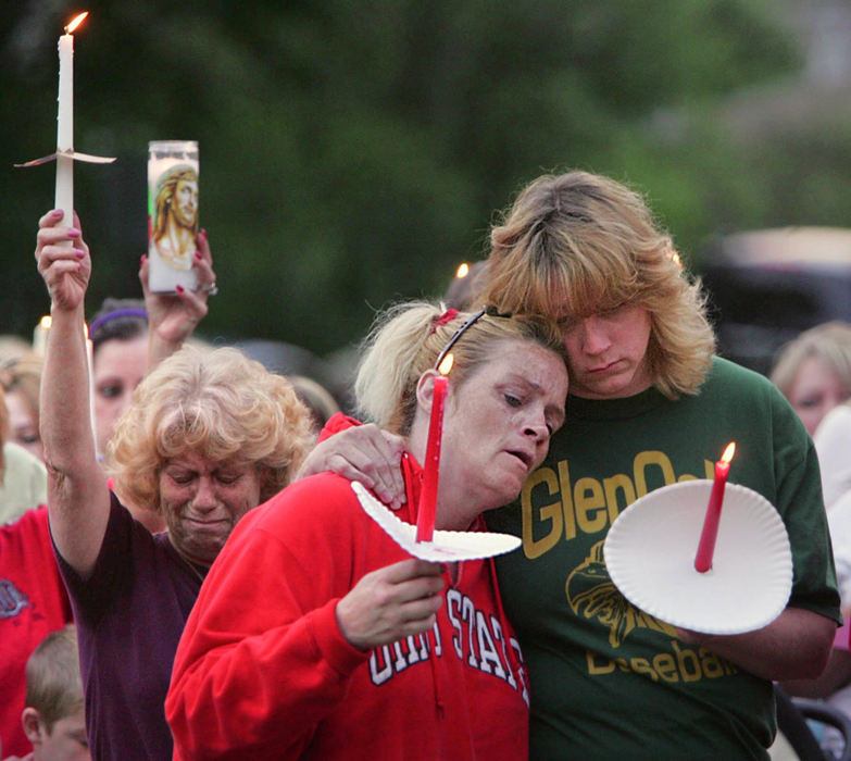 First Place, Team Picture Story - Ed Suba Jr. / Akron Beacon JournalMourners Mary Domer of Springfield Township, Jene Michalek of Canton and Kim Shoup of Uniontown attend a vigil outside the Essex Street home of Jessie Marie Davis in Lake Township. 