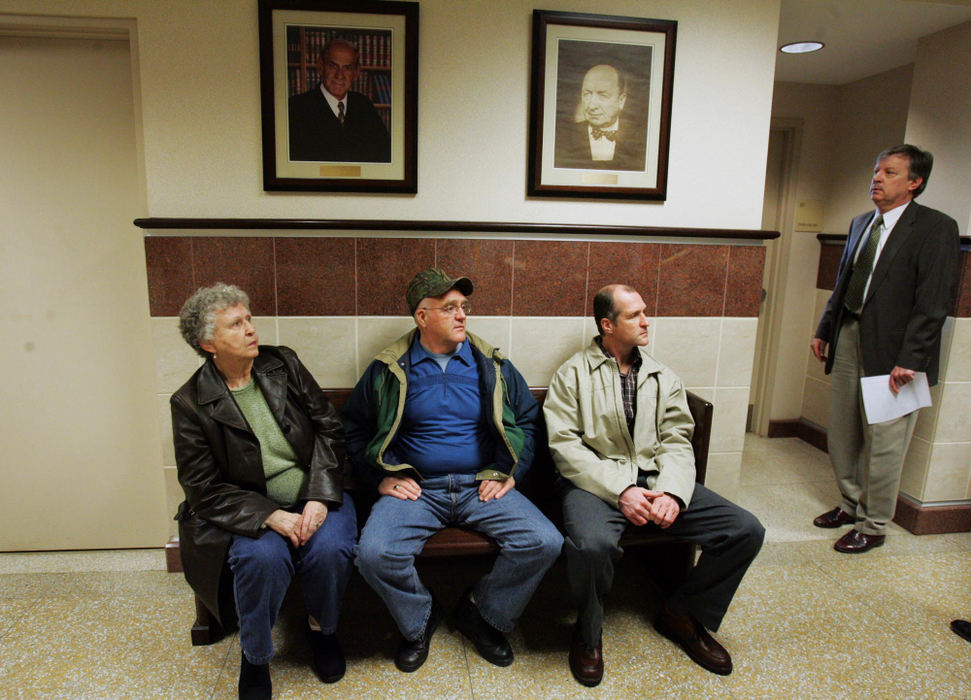 Third Place, Team Picture Story - Mike Cardew / Akron Beacon JournalLouise and Guy Resh sit with son Randy outside Common Pleas Judge Laurie J. Pittman's courtroom before a hearing on a gag order as Portage County Prosecutor Tom Buchannan looks into the courtroom.