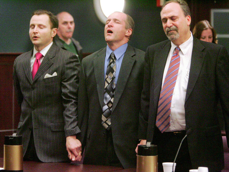 Third Place, Team Picture Story - Mike Cardew / Akron Beacon JournalRandy Resh (center) and attorneys Gregory Robey (left) and Mark Marein react as not guilty verdicts are read in Portage County Common Pleas Court in his re-trial for the murder of Connie Nardi.