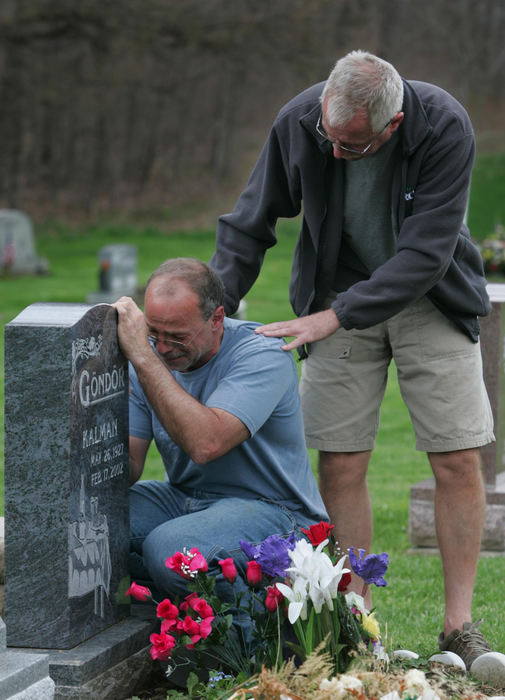 Third Place, Team Picture Story - Mike Cardew / Akron Beacon JournalJim Gondor comforts brother Bob at the grave of their father, Kalman, who died in February 2002 while Bob was in prison. Bob Gondor had said the first thing he would do when he was truly free was to visit the grave. Earlier in the day prosecutors said that all charges had been dismissed and he would not face a retrial in the case.