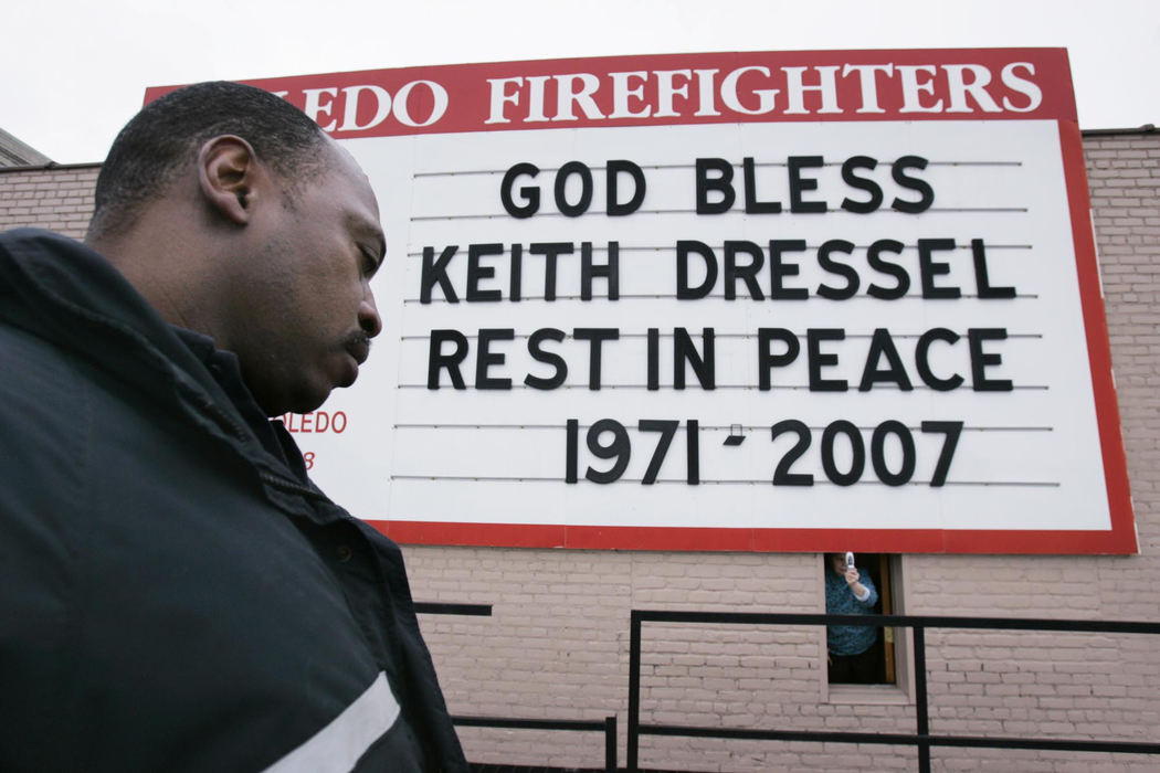 Award of Excellence, Team Picture Story - Lori King / The BladeFirefighter Oliver Harris, from Station 13, after placing a memorial message to Detective Keith Dressel, on Local 92 building in downtown Toledo.